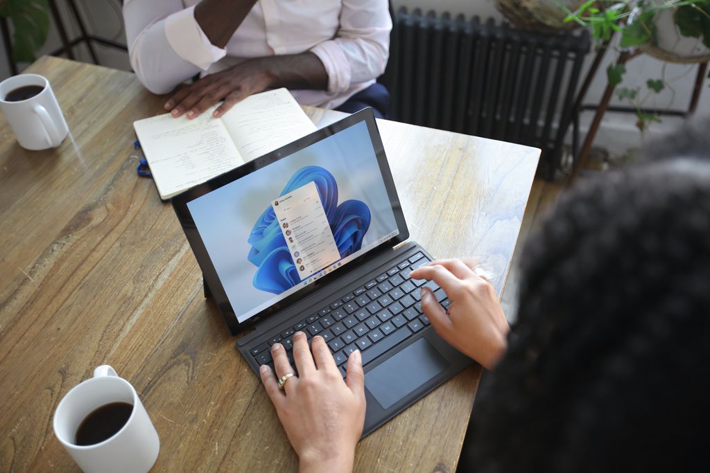 Mulher digita em um notebook com Windows 11
