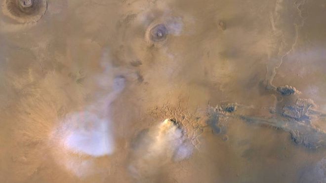 A nuvem amarelo-branca no centro inferior desta imagem é uma "torre de poeira" de Marte. As plumas azul-branco são nuvens de vapor de água (Imagem: Reprodução/NASA/JPL-Caltech/MSSS)