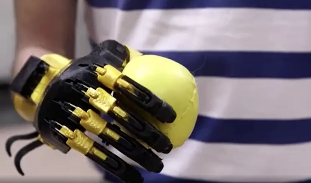 Sergio Peralta segurando uma bola com sua prótese impressa em 3D (Imagem: Reprodução/CBS YouTube)