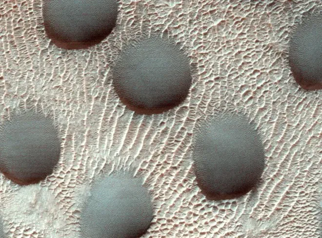 ...e as mesmas dunas em fotos tiradas anteriormente, com superfície congelada (Imagem: Reprodução/NASA/JPL-Caltech/University of Arizona)