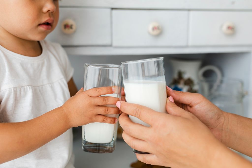 Criança e adulto segurando copo Criança e adulto segurando copo