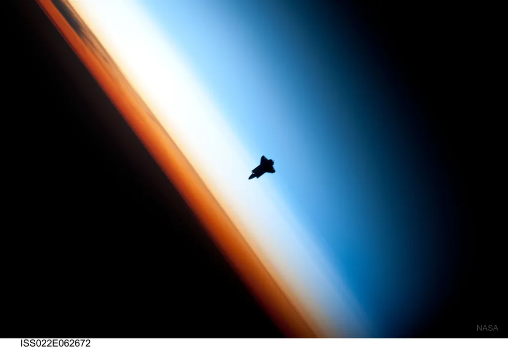 O ônibus espacial Endeavour fotografado em 2010, com as camadas atmosféricas da Terra brilhando ao fundo (Imagem: Reprodução/NASA, Expedition 22 Crew)