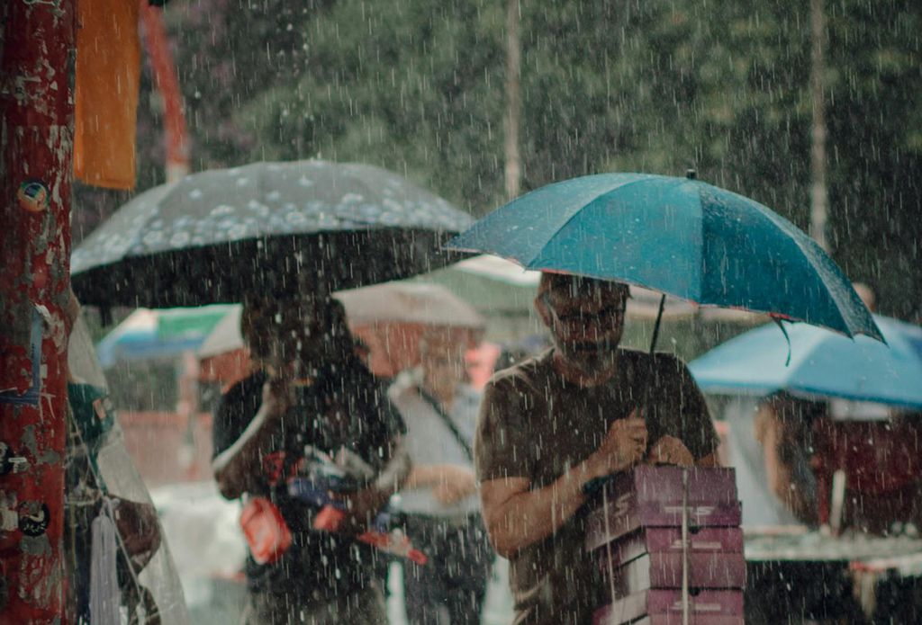 pessoas com guarda-chuva na rua durante tempestade