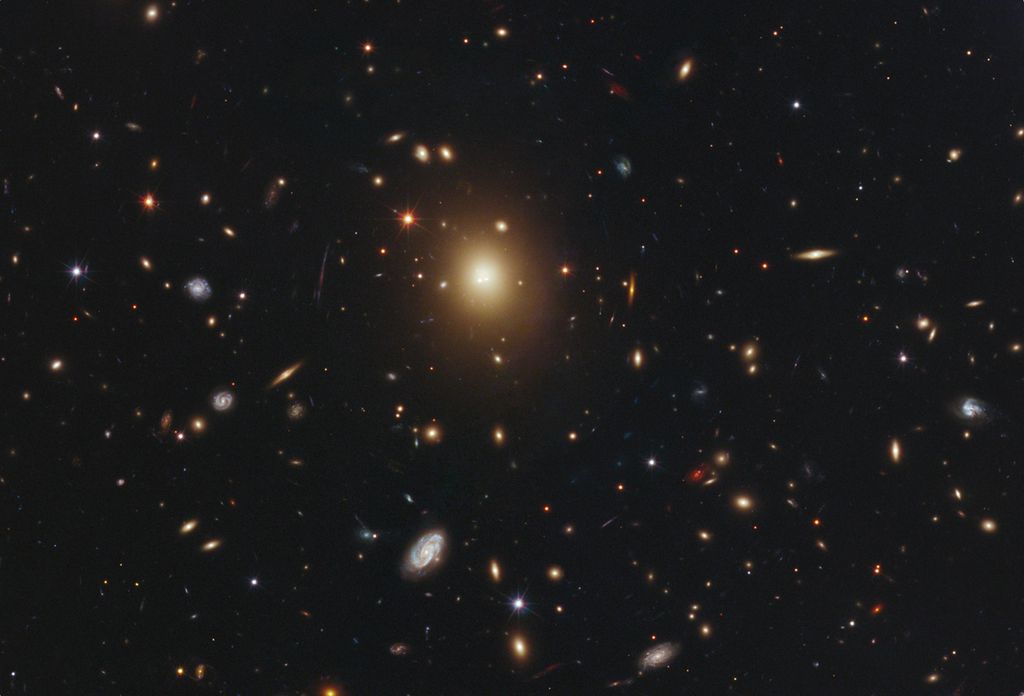 A galáxia elíptica gigante no centro desta imagem é a mais massiva e mais brilhante do aglomerado de galáxias Abell 2261 (Imagem: Reprodução/NASA/ESA/M. Postman/STScI/T. Lauer/NOAO/Tucson/CLASH team)