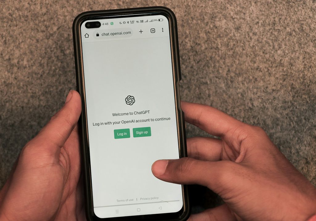 Mão segura um celular com o ChatGPT aberto