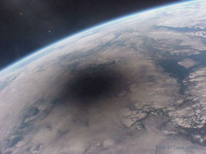 Foto do eclipse visto do espaço, revelando a sobra da Lua projetada na Terra (Imagem: Reprodução/Mir Crew 27/CNES)