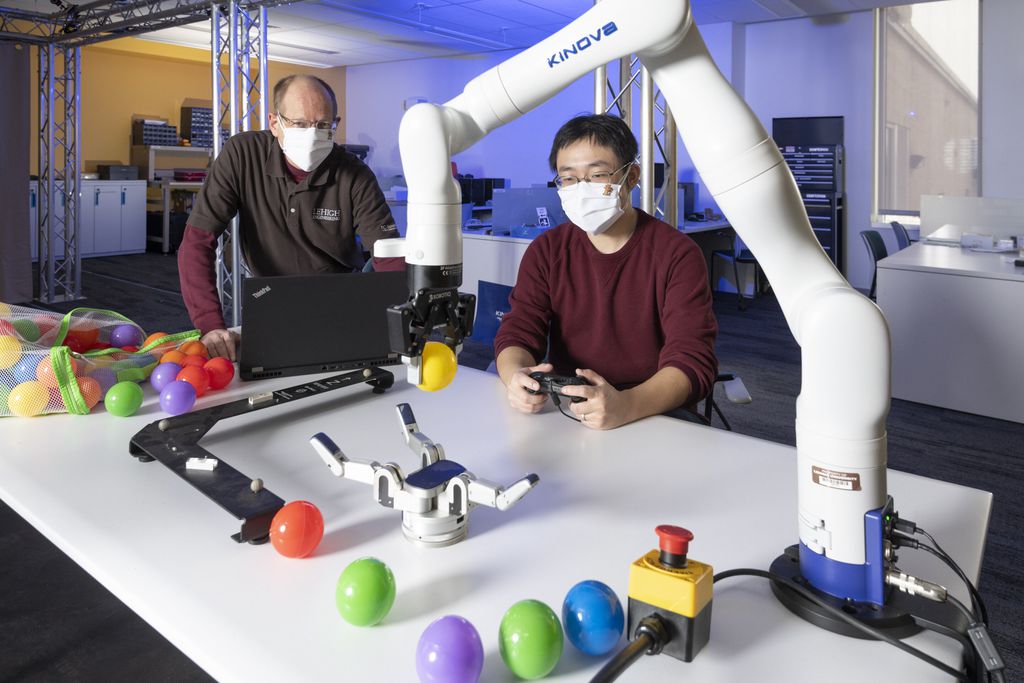 Pesquisadores Jeff Trinkle e Jinda Cui operando o braço robótico capaz de manipular objetos (Imagem: Reprodução/Lehigh University)