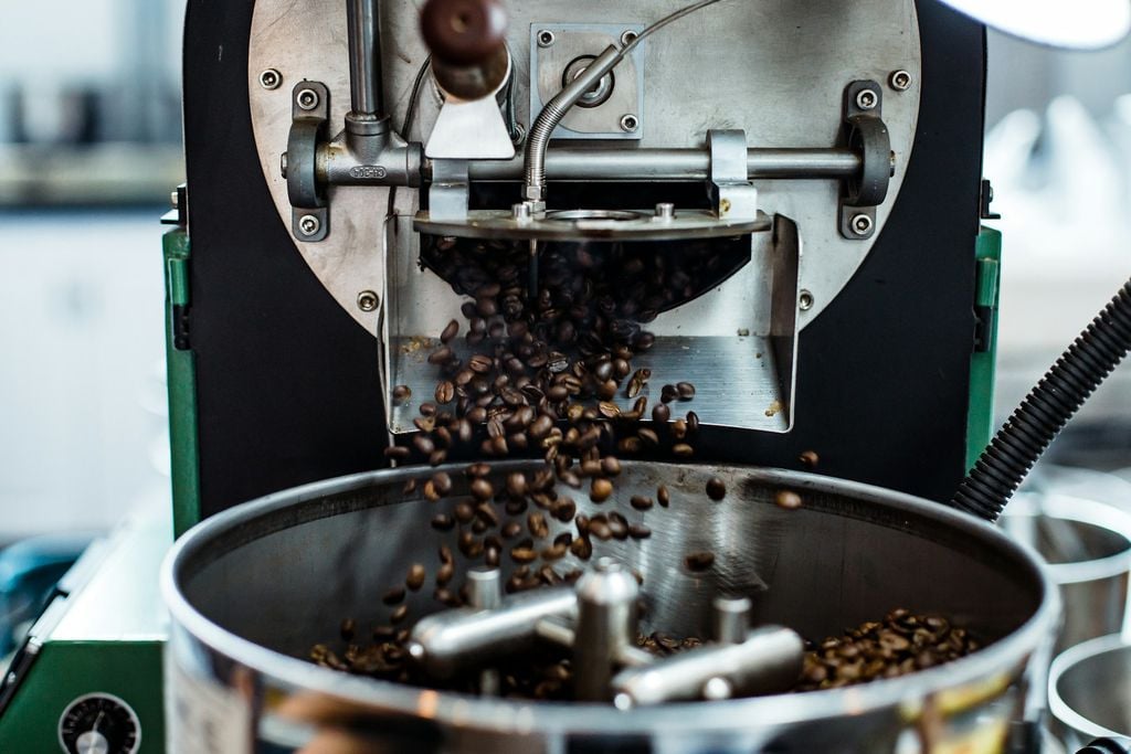 Imagem de grãos verdadeiros de café sendo moídos, o que não é café fake