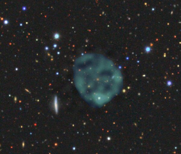 Essa "bolha" esverdeada é o ORC 1, e o ponto alaranjado em seu meio é uma galáxia que ainda não se sabe se faz parte do ORC (Imagem: Reprodução/Bärbel Koribalski, based on ASKAP data, with the optical image from the [Dark Energy Survey](https://www.darkenergysurvey.org), Author provided)