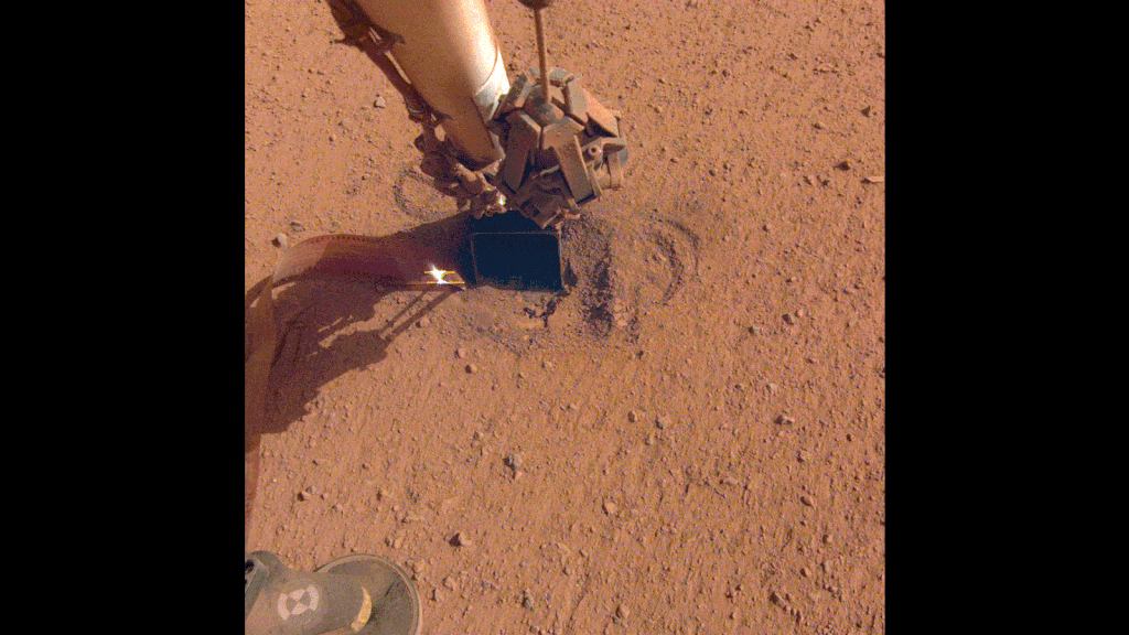 Aqui, o braço robótico se retrai e revela onde a toupeira está tentando cavar (Imagem: Reprodução/NASA/JPL-Caltech)