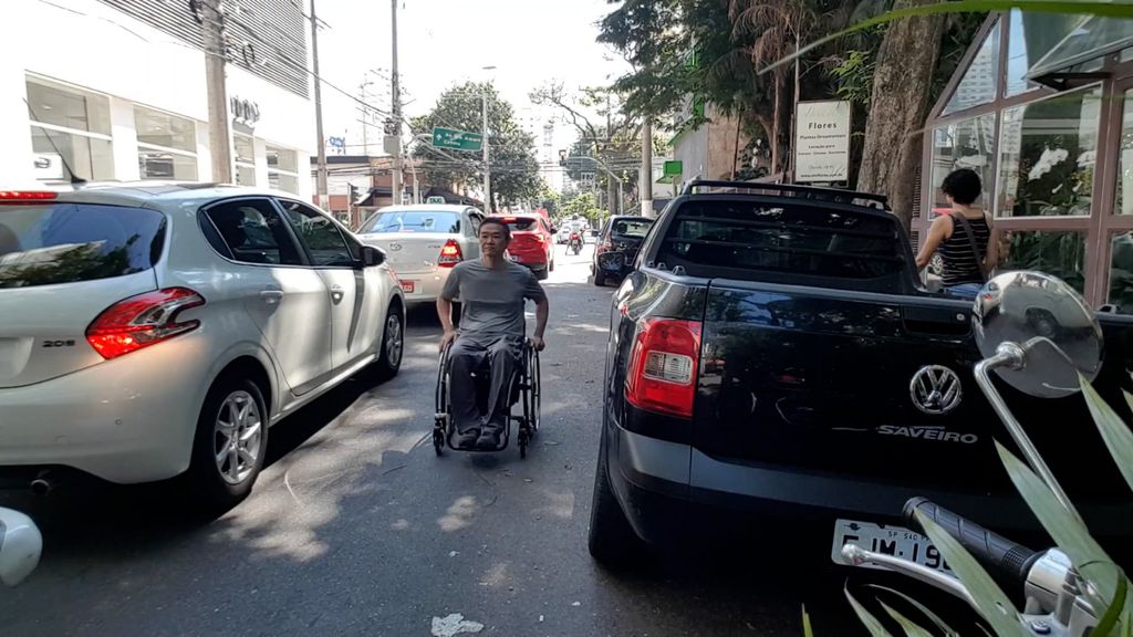 Ricardo Shimosakai circulando com sua cadeira entre os carros