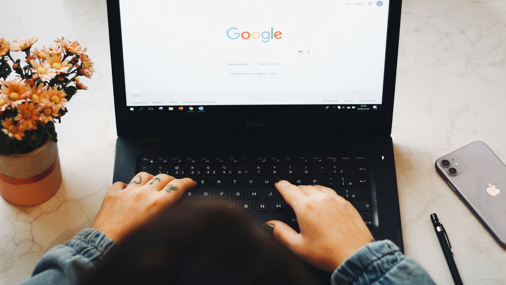 Homem digitando em um notebook com o site Google aberto