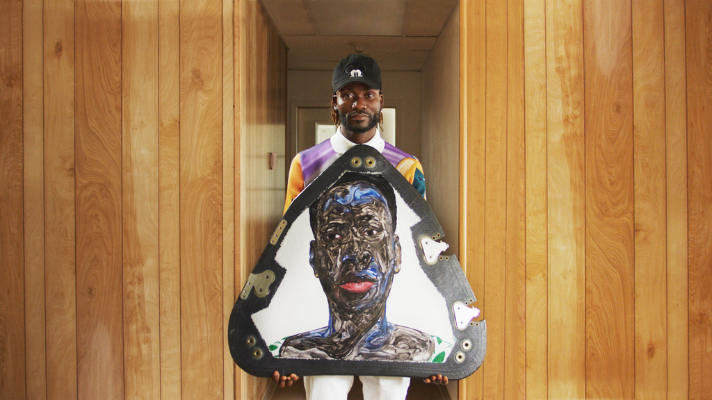 O artista Amoako Boafo com um dos retratos que estarão instalados na cápsula (Imagem: Reprodução/Uplift Aerospace)