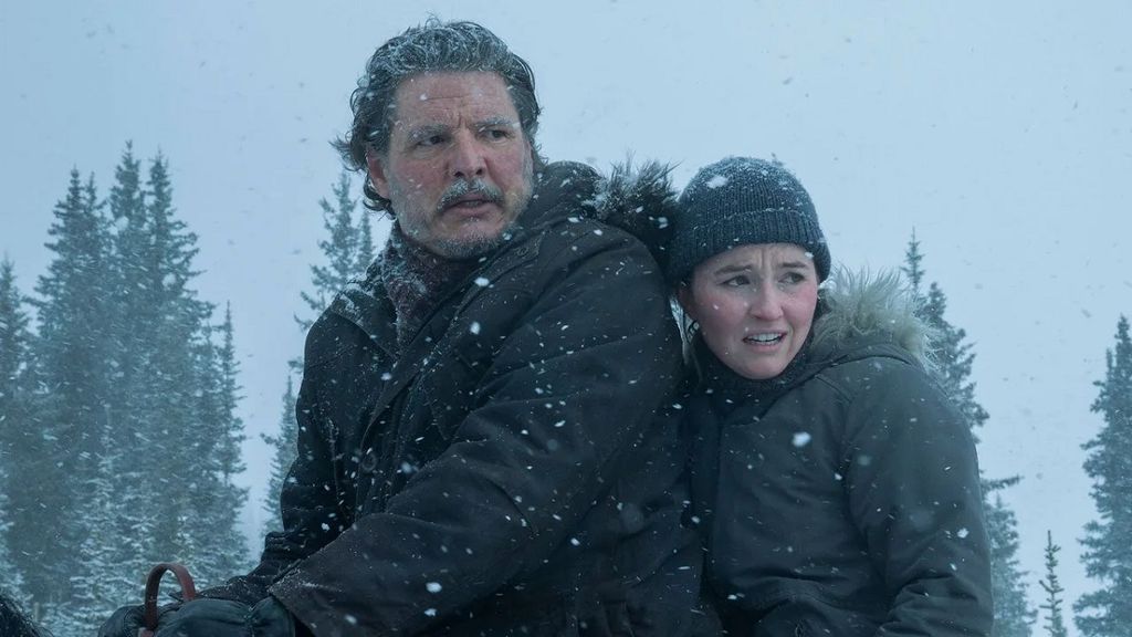 Pedro Pascal e Kaitlyn Dever montados em um cavalo em uma nevasca
