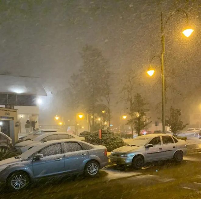 Neve caindo sobre carros