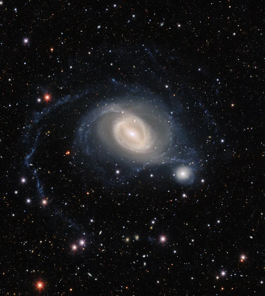 As duas galáxias estão cercadas por incríveis formações de novas estrelas, impulsionadas pelo processo de fusão (Imagem: Reprodução/Dark Energy Survey/DOE/FNAL/DECam/CTIO/NOIRLab/NSF/AURA/TA Rector/J. Miller/M. Zamani/D. de Martin)