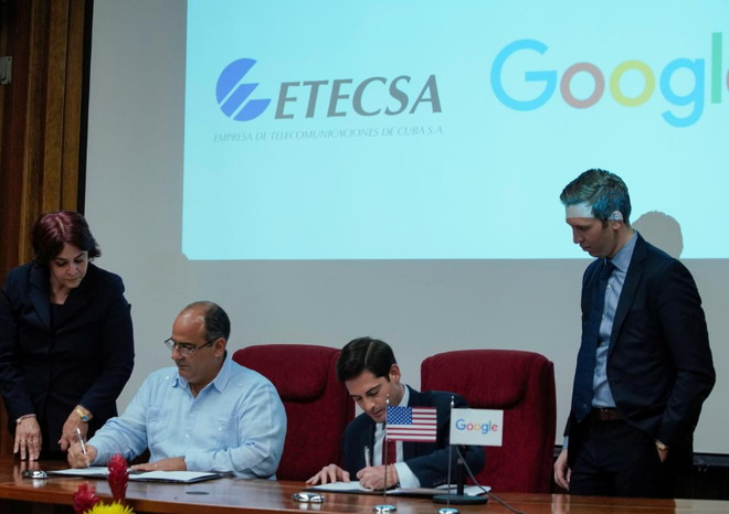 O chefe de estratégia e operações em Cuba da Google, Brett Perlmutter, assina parceria em conjunto com o vice-presidente de investimentos da ETECSA, Luis Adolfo Reyes (Foto: Alexandre Meneghini/REUTERS)