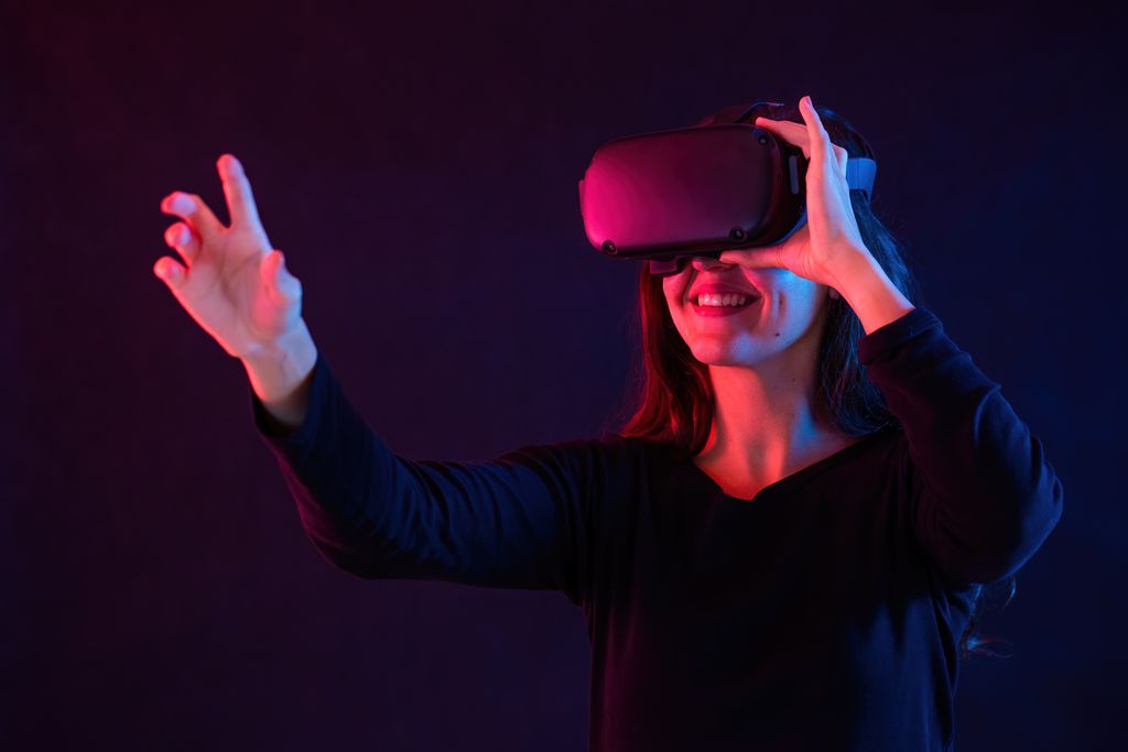 Mulher usando óculos de realidade aumentada sobre a luz violeta (Imagem: WildMediaSK/Envato)