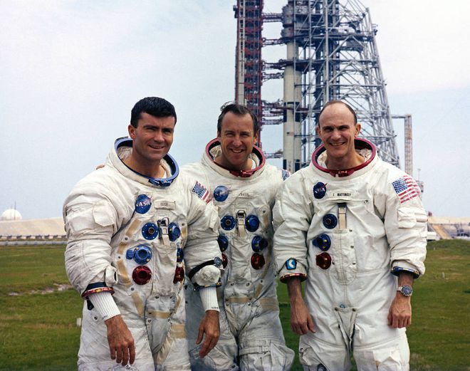 Da esquerda para a direita, haise, Lovell e Mattingly com o foguete Saturn V ao fundo (Imagem: Reprodução/NASA)