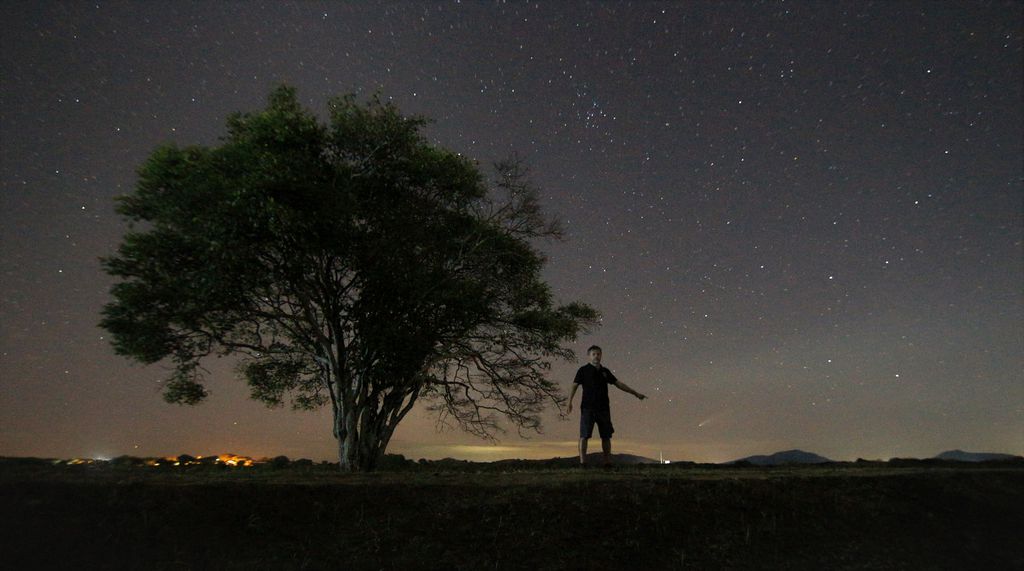 O cometa é o brilho apontado pela pessoa na foto tirada em Caucaia, Ceará (Foto: Reprodução/Paulo Regis)