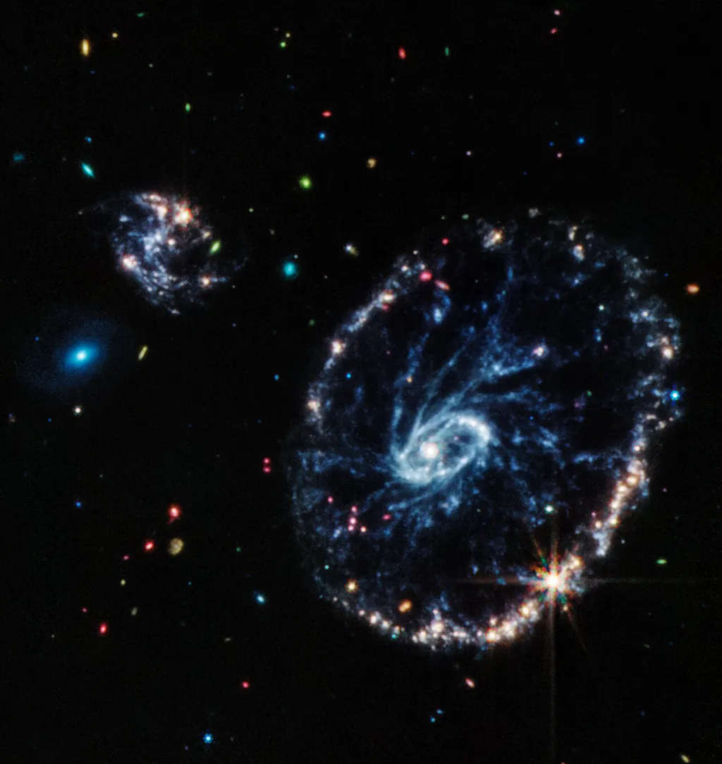 Galáxia Cartwheel pela câmera MIRI, do James Webb, que captura dados no infravermelho médio; regiões empoeiradas e estrelas jovens dentro da Galáxia Cartwheel foram reveladas com maior detalhes (Imagem: Reprodução/NASA/ESA/CSA/STScI)