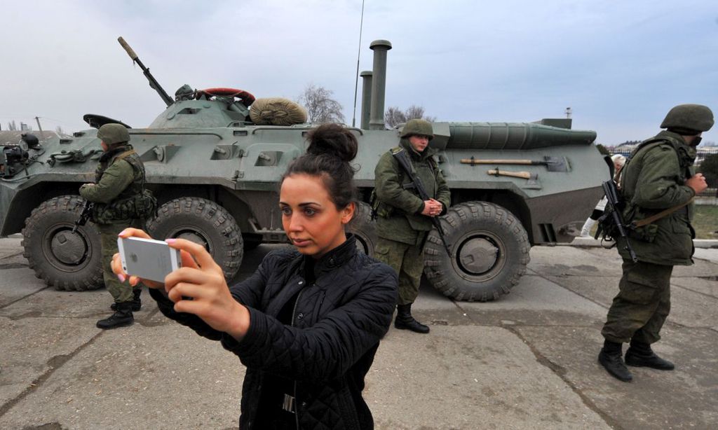 Moradora da Crimeia tira selfie com soldados russos (Imagem: OperaMundi)