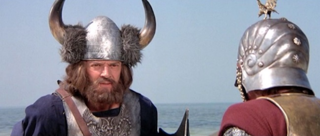 Um dos filmes que perpetuou a lenda dos capacetes com chifres foi O Viking, de 1978, que mostrava os nórdicos com armaduras de metal que não existiam e capacetes ridiculamente ornados (Imagem: American International Pictures)