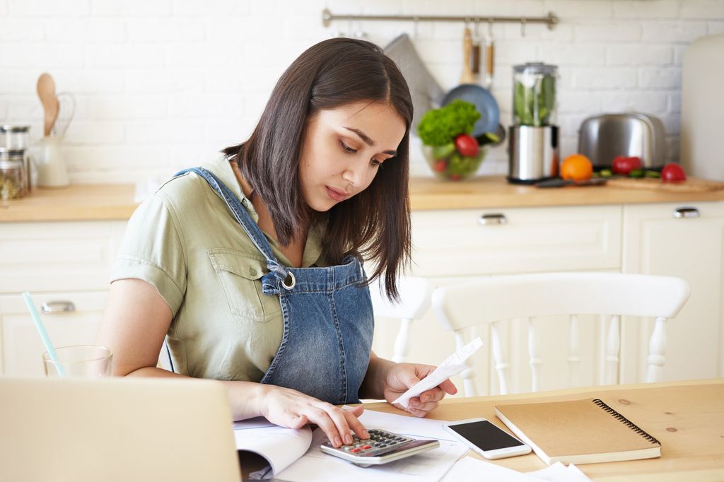 Mulher com expressão preocupada analisa suas contas financeiras
