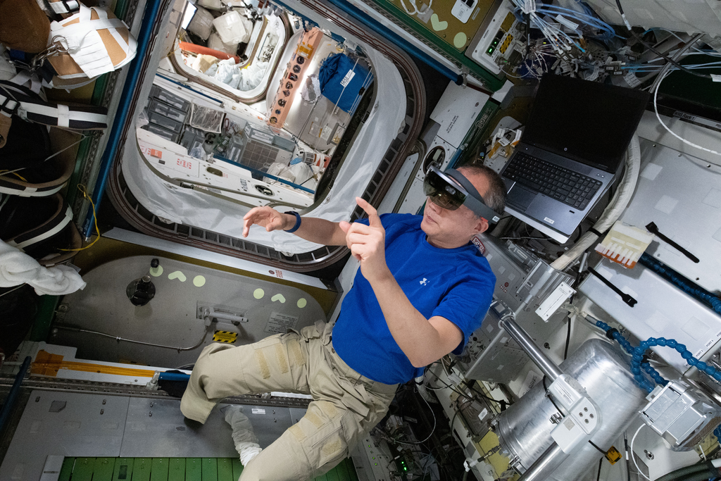 Noguchi se preparando para realizar a manutenção na esteira enquanto recebia as instruções pelos óculos de AR (Imagem: Reprodução/NASA)