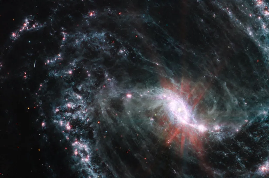 Galáxia NGC 1365; na imagem, há agrupamentos de gás e poeira que absorveram a luz das estrelas em formação, e a emitiram de volta no infravermelho (Imagem: Reprodução/NASA, ESA, CSA, and J. Lee (NOIRLab), A. Pagan (STScI)