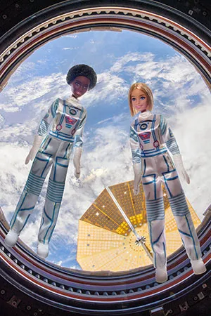 Duas bonecas Barbie flutuando a bordo da ISS (Imagem: Reprodução/Mattel)