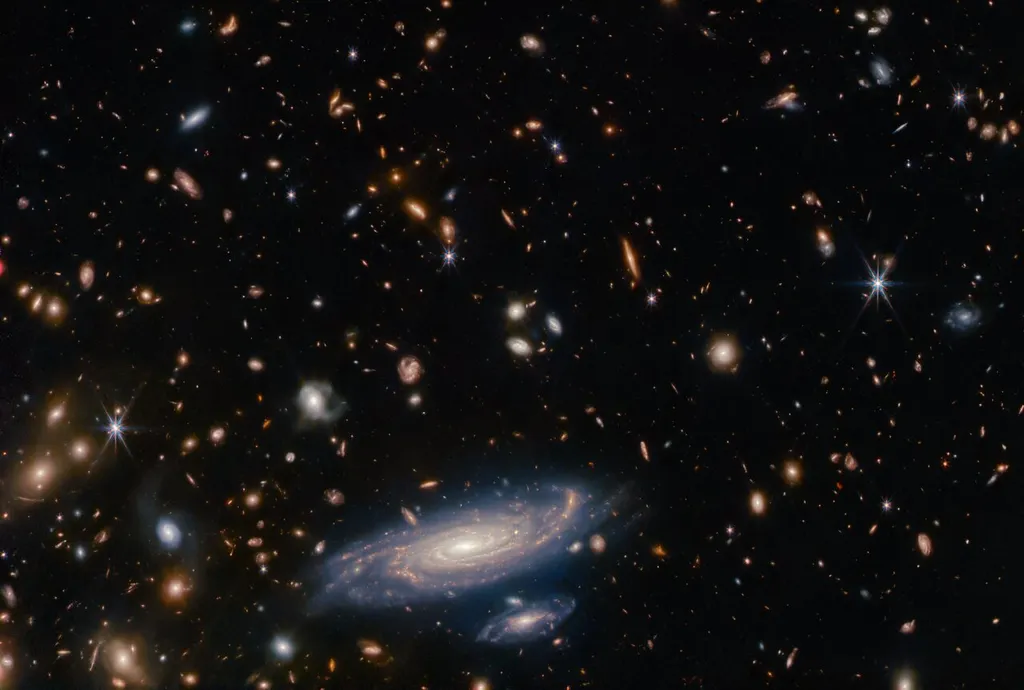 Galáxias e estrelas observadas pelo telescópio James Webb; a galáxia LEDA 2046648, do tipo espiral, aparece na parte inferior da imagem (Imagem: Reprodução/ESA/Webb, NASA & CSA, A. Martel)