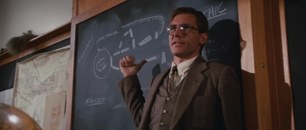 Em sala de aula, Indiana Jones é um acadêmico como qualquer outro, lecionando sobre arqueologia. Quando vai a campo, como também vão os arqueólogos, é que sua atitude muda bastante (Imagem: Paramount Pictures)