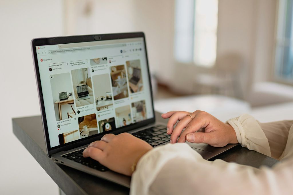 Pessoa olhando feed do Pinterest no notebook Pessoa olhando feed do Pinterest no notebook