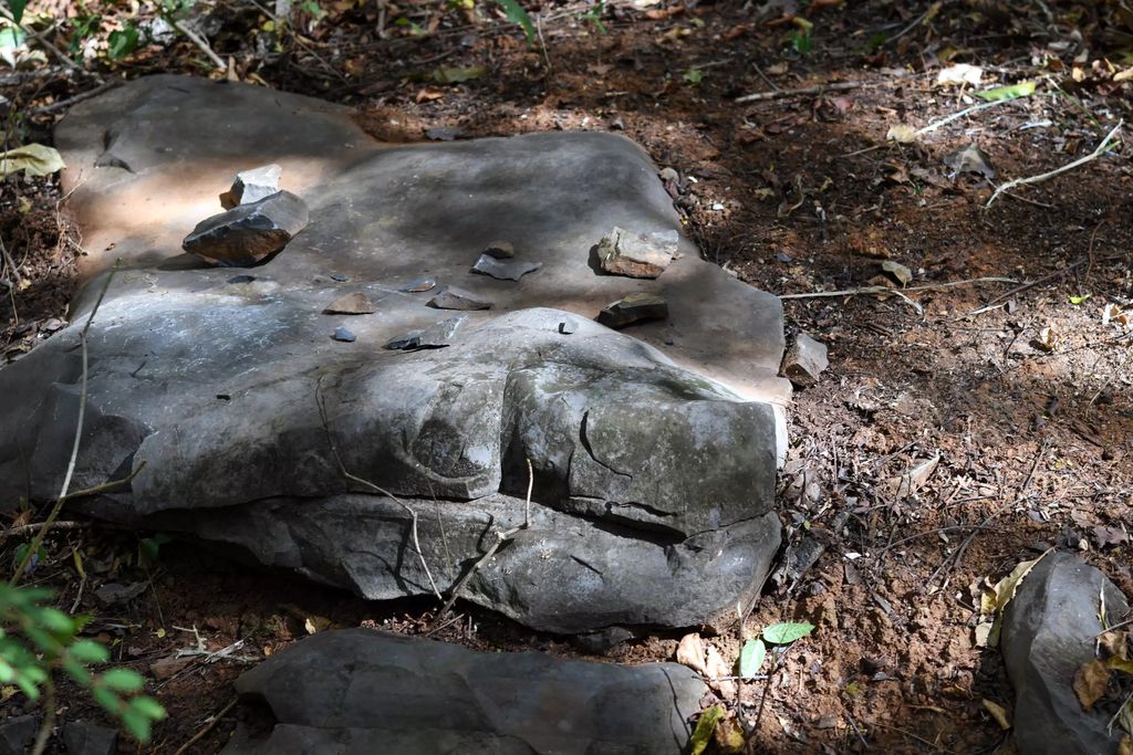 Pedra grande com várias lascas de pedra sobre seu topo