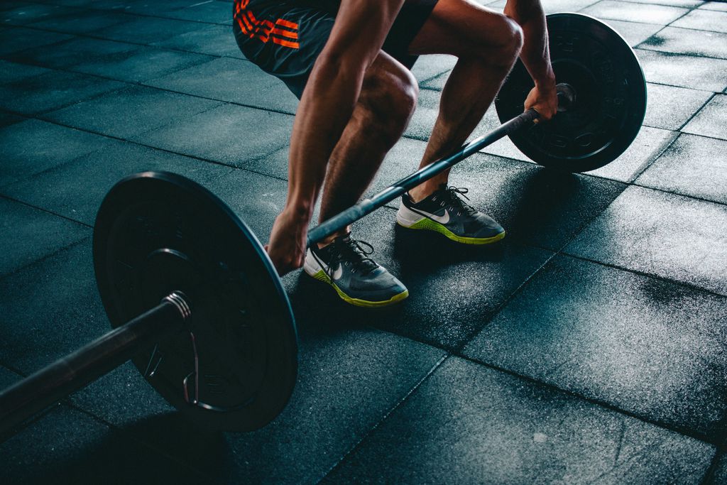 Homem durante treino de musculação com barra