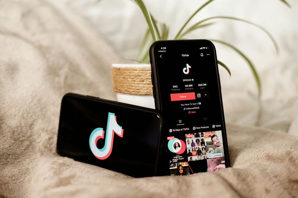 Celular com TikTok aberto e outro celular com o logo do TikTok