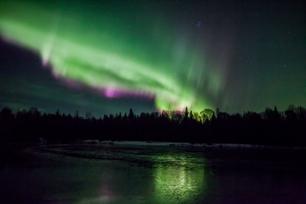 Aurora boreal, fenômeno que ocorre graças à interação entre as partículas cósmicas e o campo magnético da Terra. Quando a aurora ocorre no sul do planeta, recebe o nome de aurora austral (Imagem: Reprodução/Dora Miller)