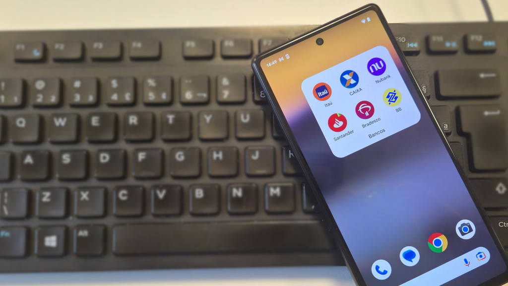 celular em cima de teclado com apps de banco a mostra