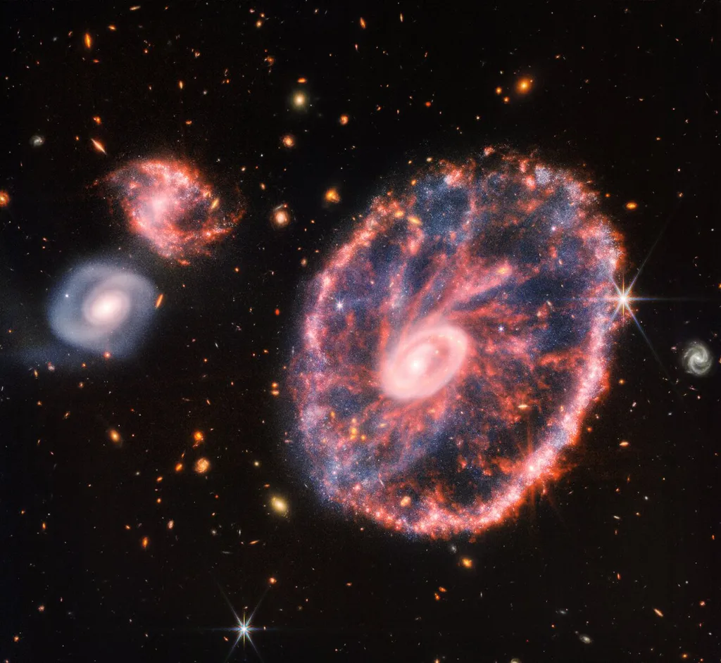 Galáxia Cartwheel e suas companheiras, em uma composição com dados das câmeras NIRCam e MIRI (Imagem: Reprodução/NASA/ESA/CSA/STScI)