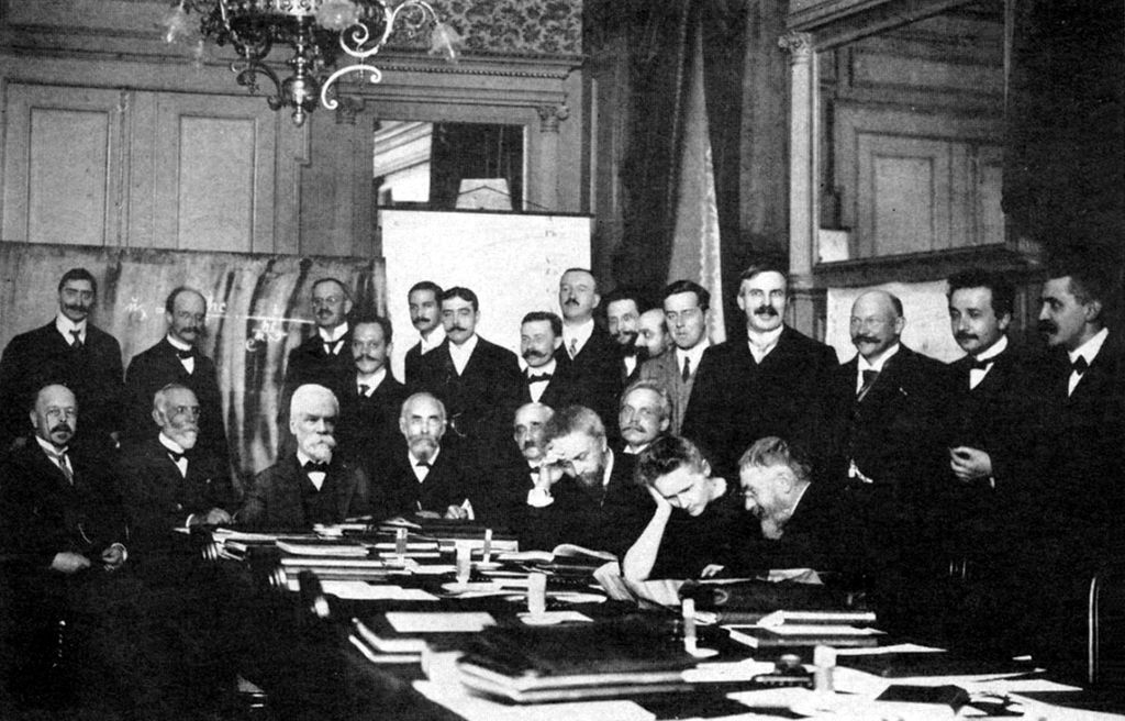 Foto da primeira edição da Conferência de Solvay, em que Marie Curie aparece junto a Albert Einstein em 1911