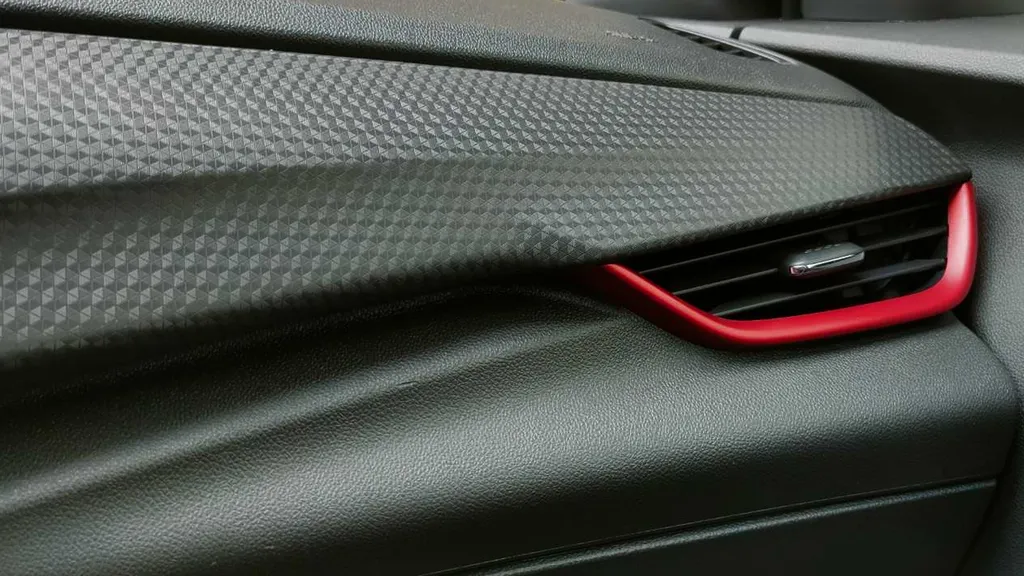 Acabamento no painel e contorno vermelho na saída de ar dão um charme ao interior do Onix RS (Imagem: Paulo Amaral/Canaltech)