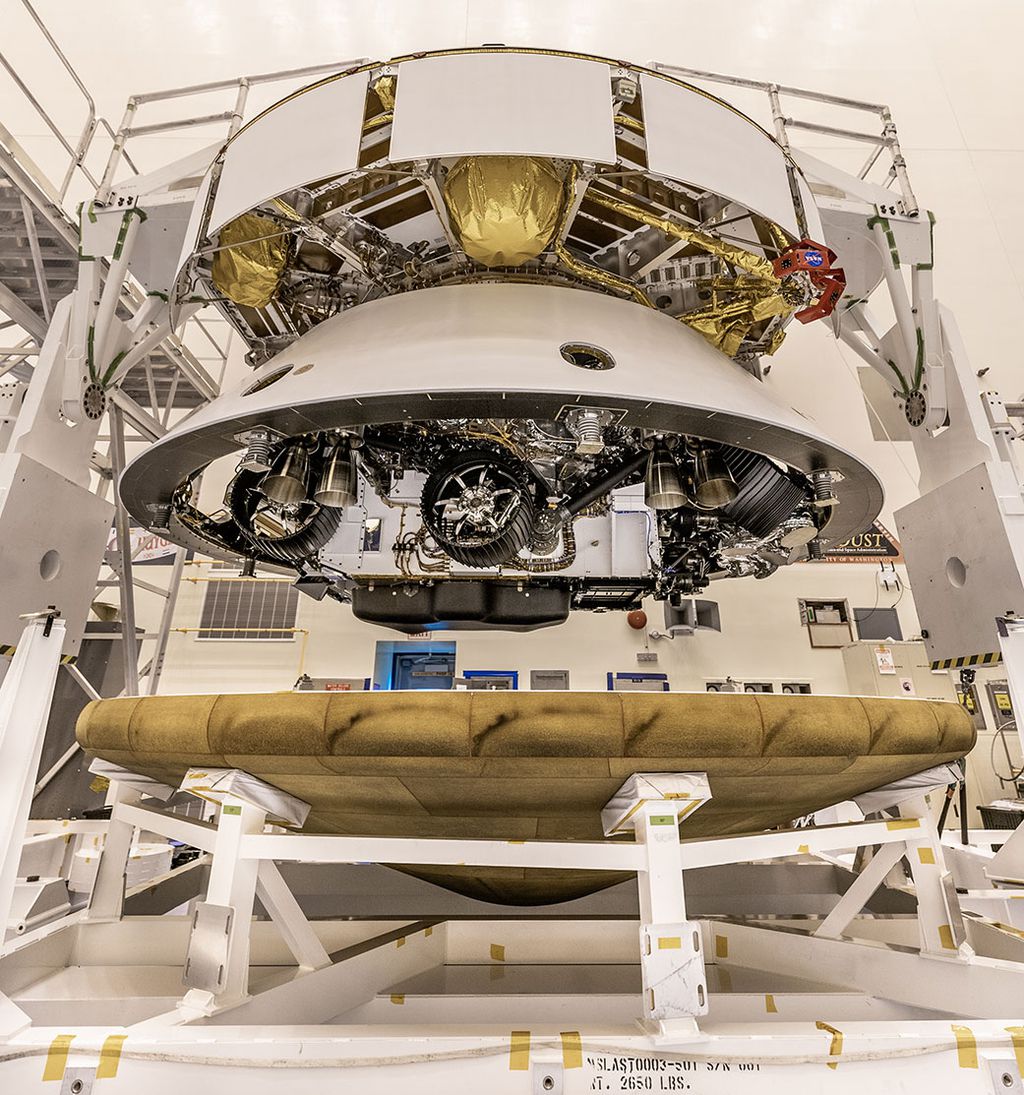 O escudo térmico de cor bronze prestes a ser fixado no rover Perseverance (Foto: NASA/JPL-Caltech/KSC)