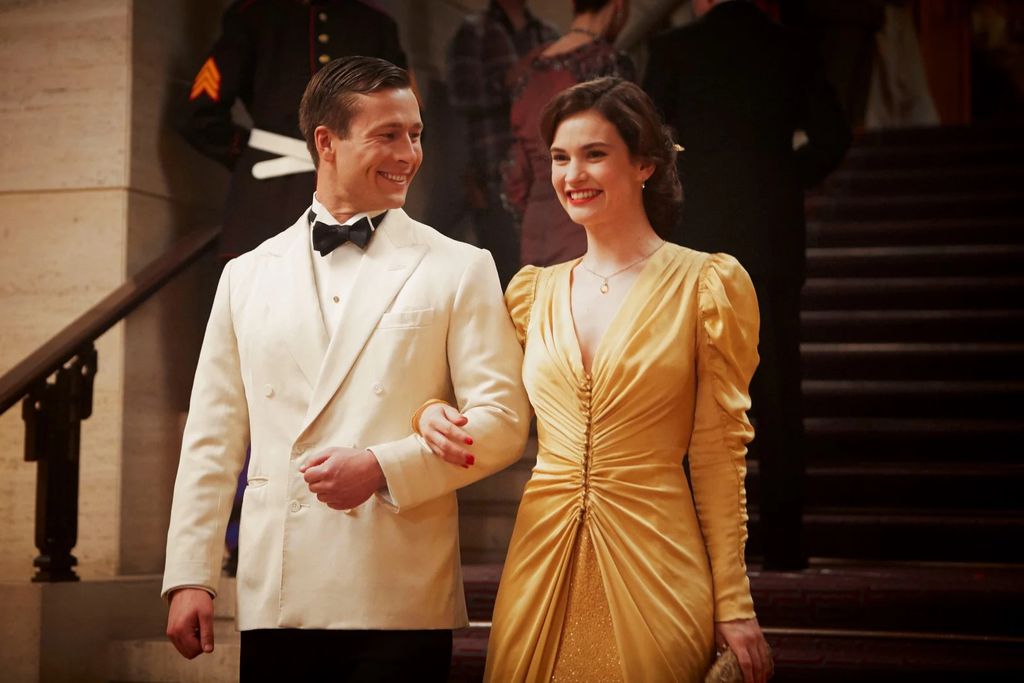 Glen Powell e Lily James em cena do filme A Sociedade Literária e a Torta de Casca de Batata