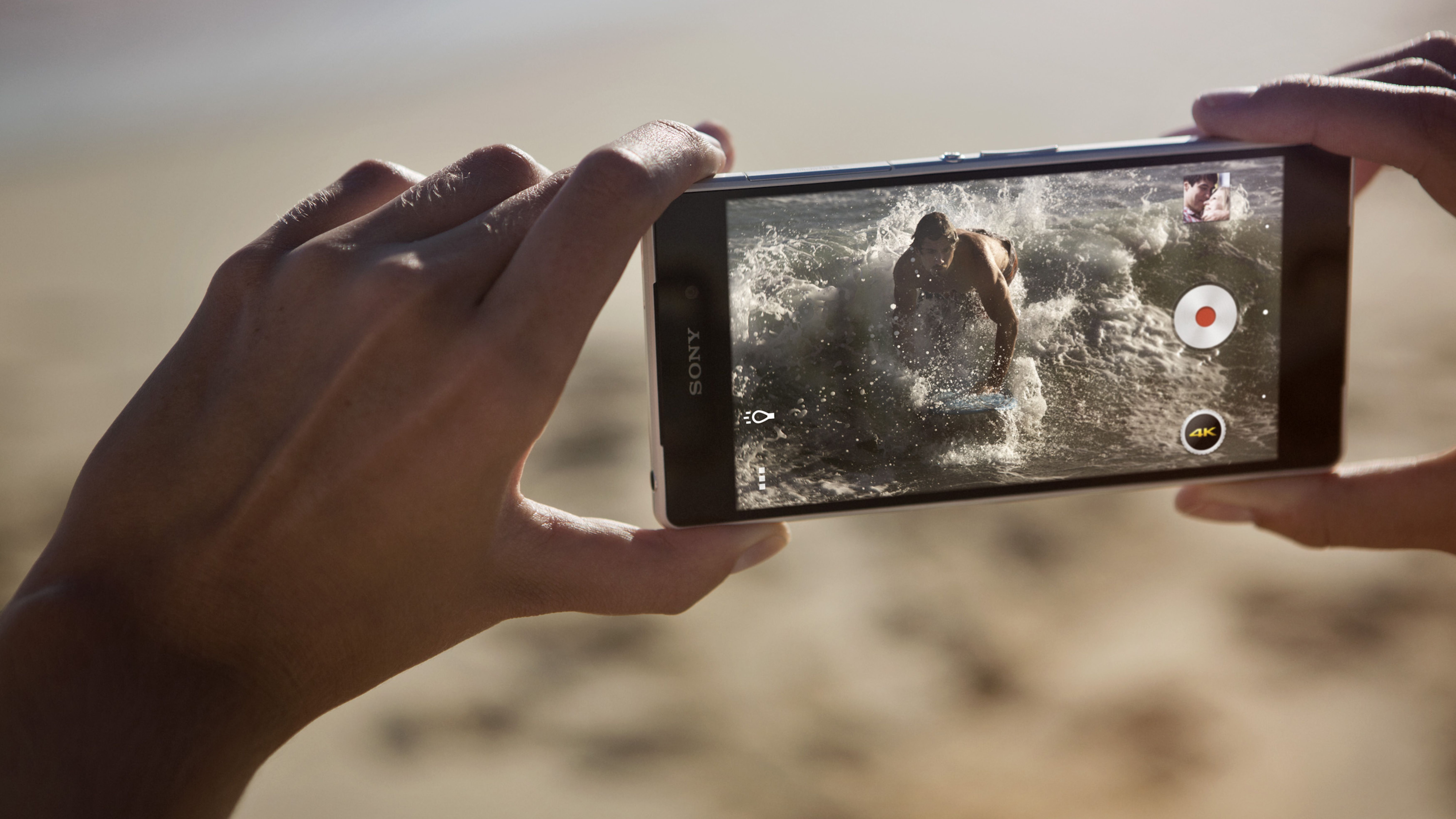 duas mãos segurando horizontalmente smartphone com botão de jogo