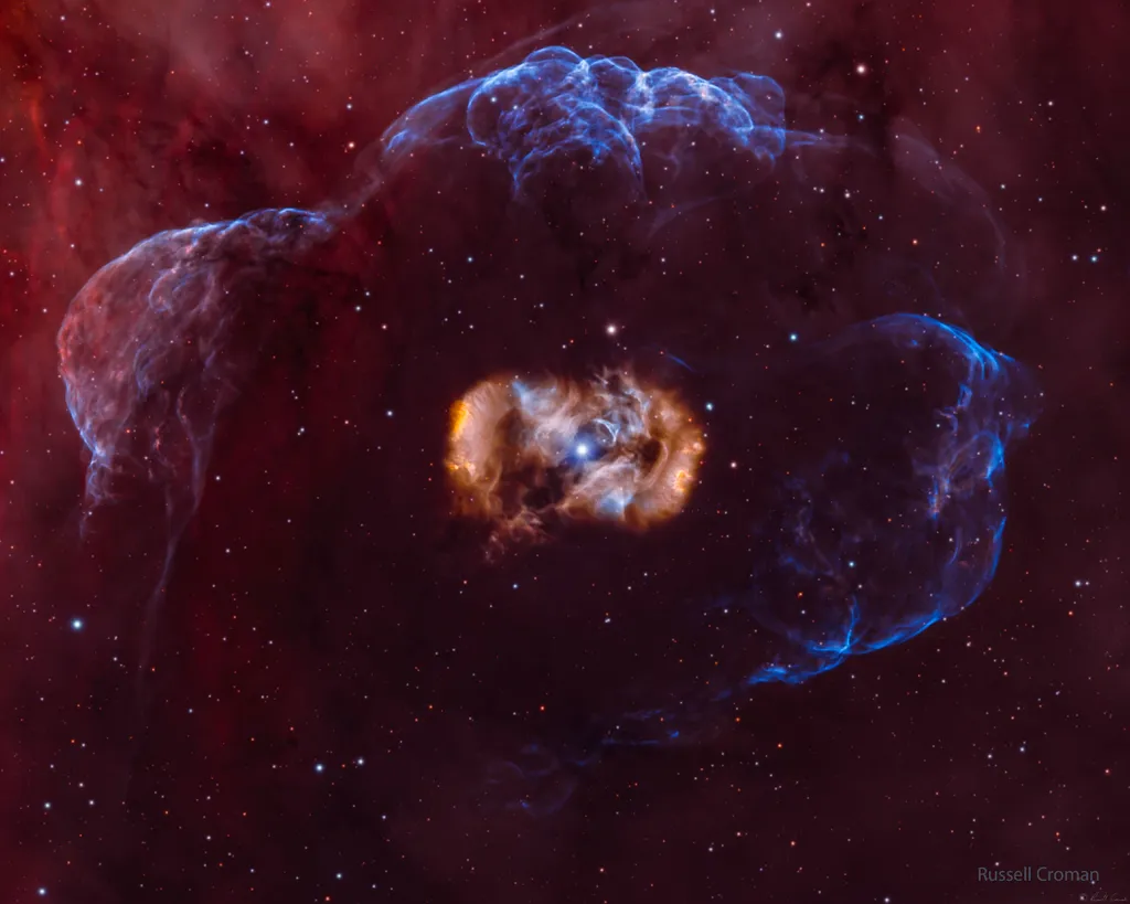 A nebulosa Ovo do Dragão é formada por duas nuvens avermelhadas bipolares e uma concha externa mais fraca (Imagem: Reprodução/Russell Croman)