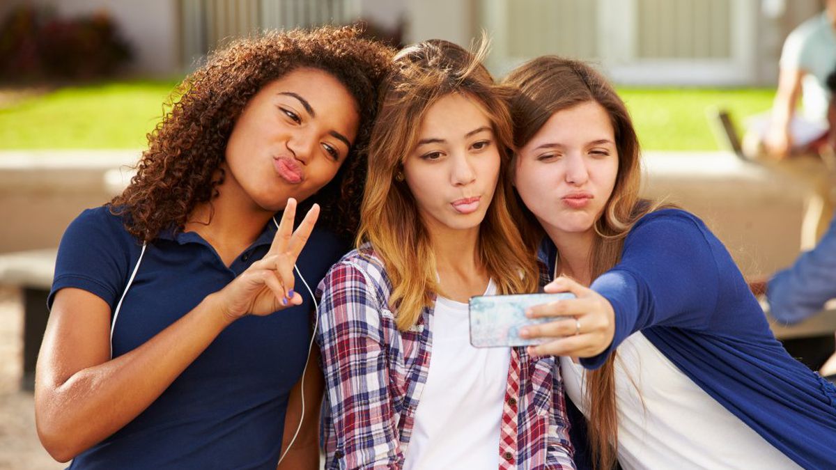 Grupo De Jovens Amigos Segurando O Smartphone Nas Mãos Se