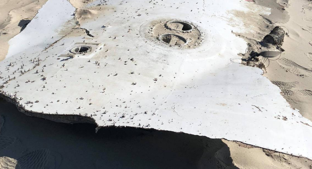 Componente de um foguete Falcon 9, da SpaceX, destacado da embarcação e que acabou encalhado em uma praia na Carolina do Norte (Foto: Angie Chris Langdon)
