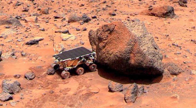 Imagem do rover Sojourner em Marte, com diversas cores: as rodas do veículo estão vermelhas pela hematita, enquanto o solo perturbado é mais escuro (Imagem: Reprodução/Mars Pathfinder)