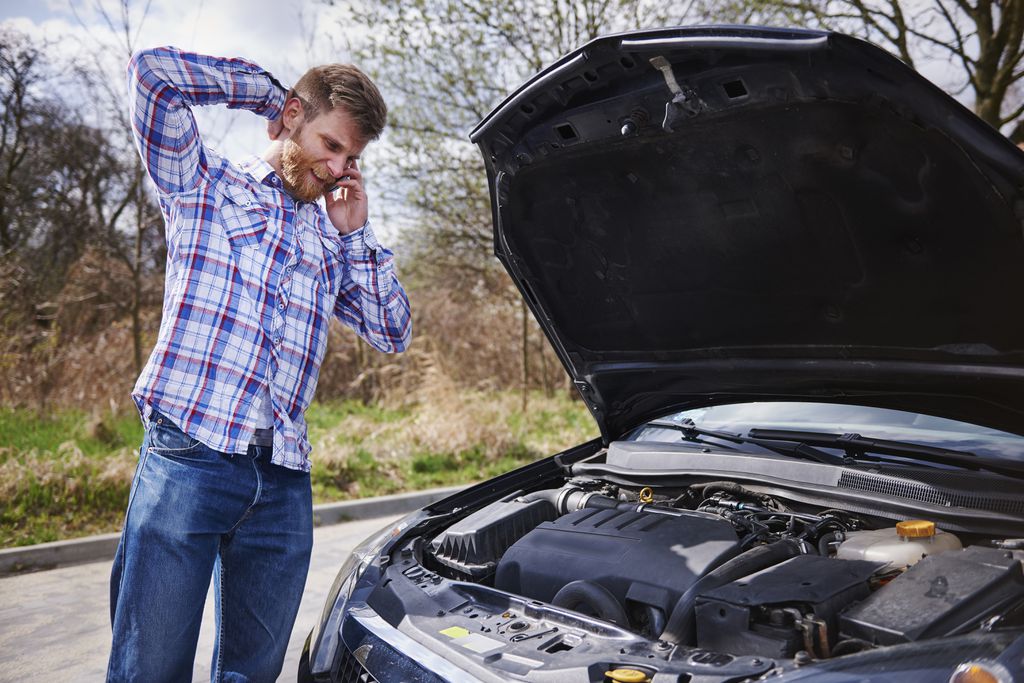 Homem com problemas no motor do carro